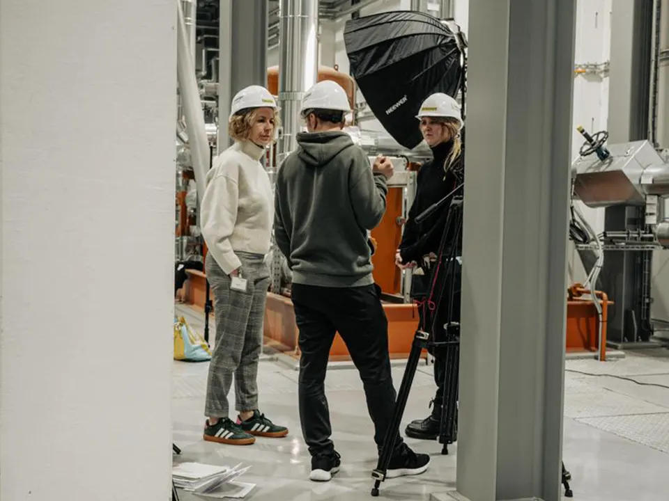 Crew mit Bauhelmen am Set in einer Industriehalle